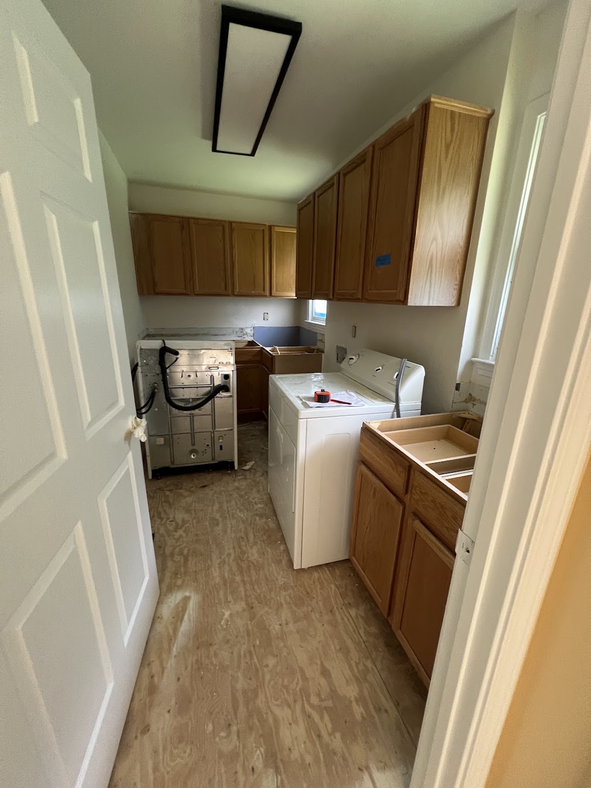 Laundry room during renovation, with existing cabinets and work surfaces being updated